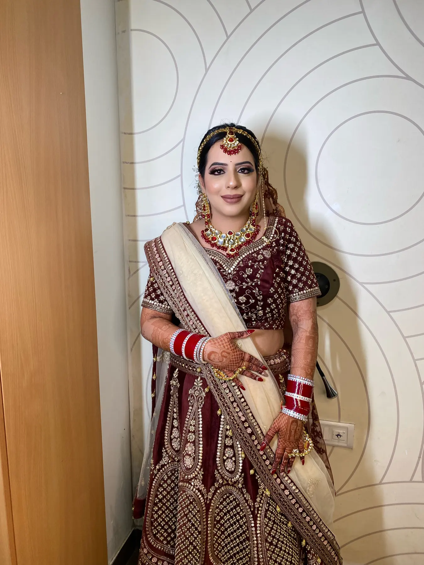 Maroon Velvet Lehenga, Standing. Bridal makeup by Madhu Gupta at MG Makeovers, Gurugram